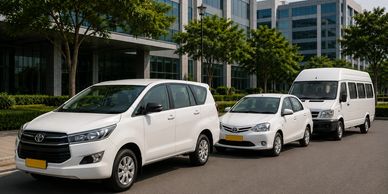 Three white vehicles parked in a row near buildings.