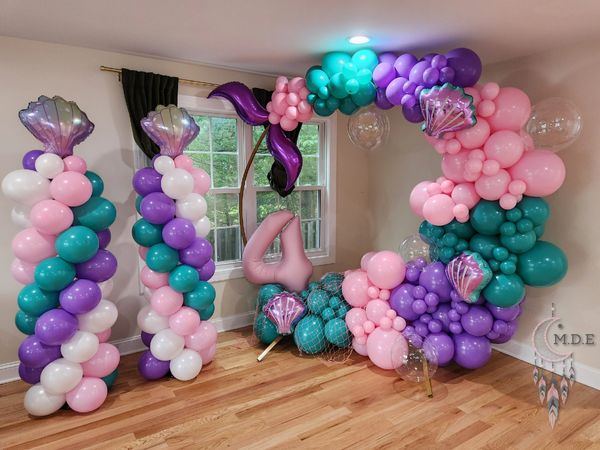 Mermaid tail balloon ring with 2 spiral balloon columns with sea shell foil toppers.
