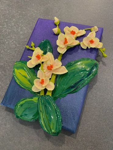 A painting of white orchids with orange centers and green leaves on a dark purple canvas.