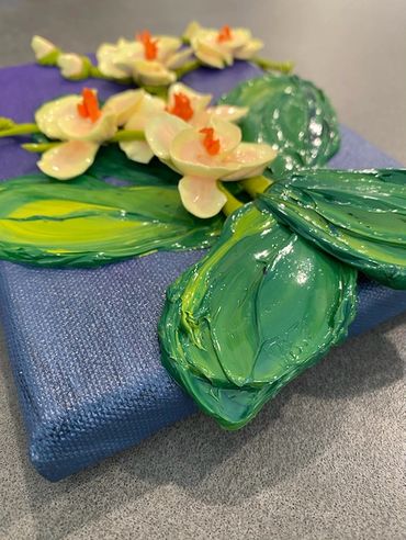 A painting of white orchids with orange centers and green leaves on a dark purple canvas.