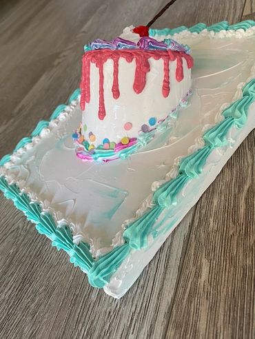A small round cake with colorful drips, confetti sprinkles, whipped cream, and a cherry.