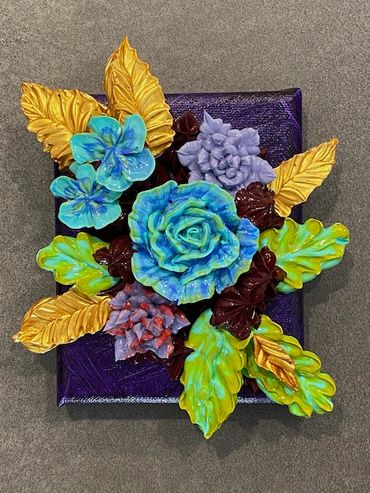 Blue and purple flowers with green and gold leaves on a dark background.