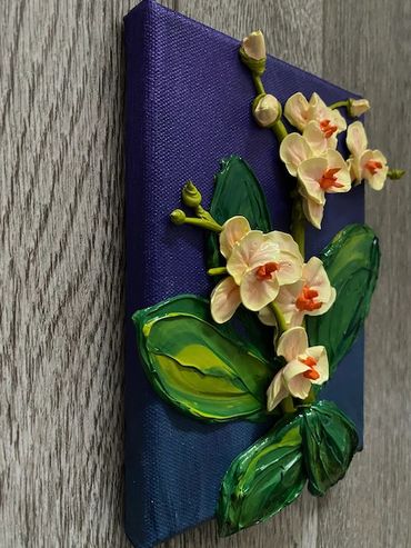 A painting of white orchids with orange centers and green leaves on a dark purple canvas.