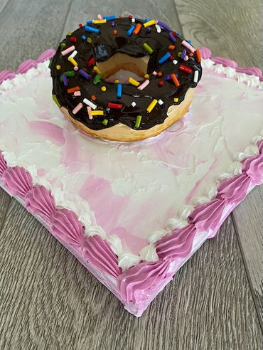 Close-up of White cake with Chocolate frosting on a pink square canvas