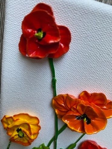 A vibrant painting of red, orange, and yellow poppies with green stems on a white canvas.