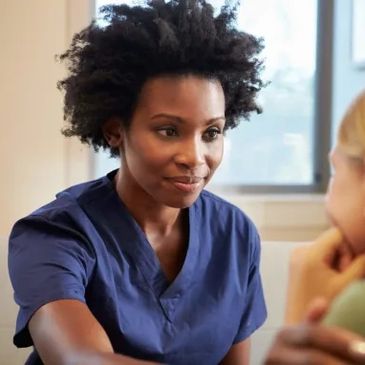 Nurse attentively listening to a patient in a caring environment.