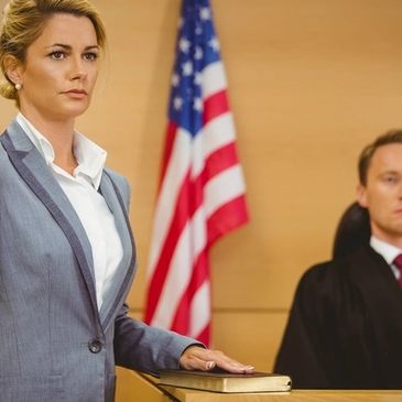 Woman taking an oath in court with judge present.