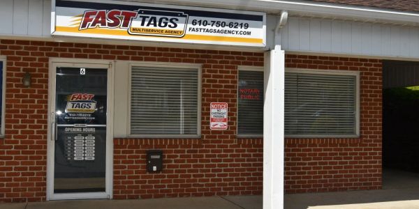 Storefront of FASTTAGS Multiservice Agency with contact details.