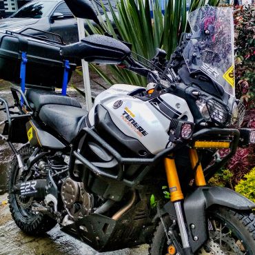 Motocicleta todo terreno Yamaha Ténéré estacionada bajo lluvia.