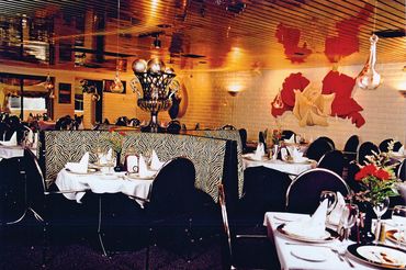 Elegant restaurant interior with zebra-patterned chairs and floral wall art.