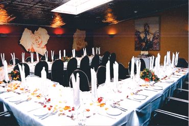 Elegant banquet setup with white tablecloths and folded napkins.