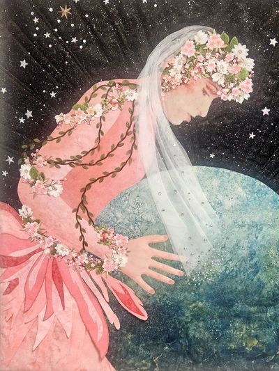 Woman adorned with flowers in a pink dress touching the Earth.