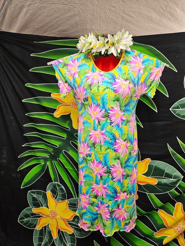 Colorful tropical dress with floral pattern and white flower crown on mannequin.