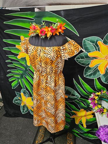 Orange and black patterned dress on a mannequin with a floral headpiece.