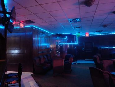 Dimly lit lounge with blue LED strip lighting and cozy seating.