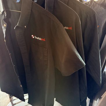 Black shirts with 'Southland' logo hanging on hangers.