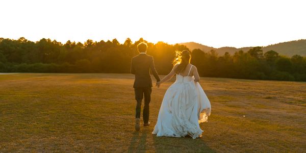 Couple holding hands walking at sunset.