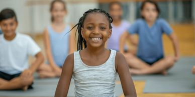 Children doing yoga for social-emotional learning at Permission to Succeed Education Center.