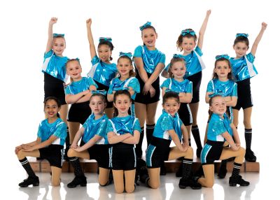 Youth dance group in blue costumes posing confidently.