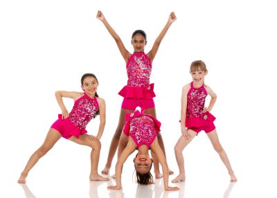 Four girls in pink dance costumes posing.