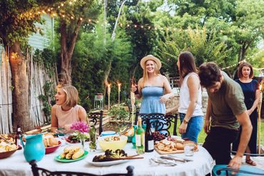 Eine Gruppe von Freunden genießt ein Abendessen im Hinterhof