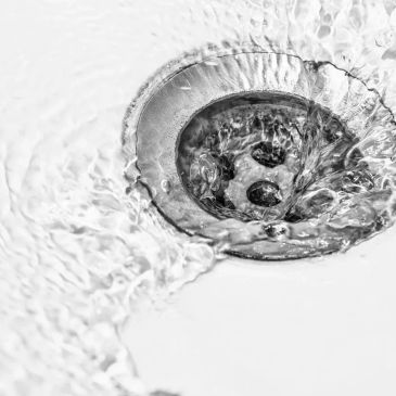 Water flowing down a drain in a sink.
