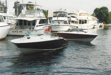 Two boats, one large and one small, docked side-by-side.