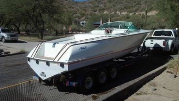 A white boat on a four-wheeled trailer.