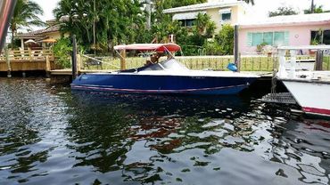 A blue boat with red accents at a dock.