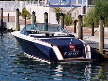 A blue and white boat with red accents docked on the water.