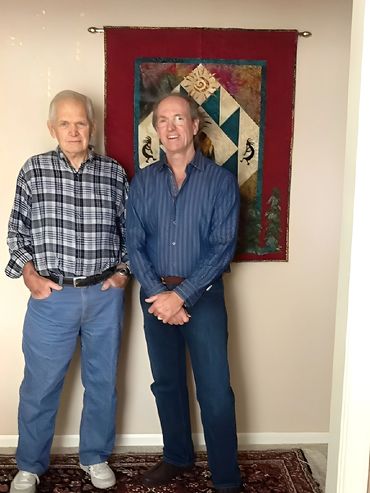 Two men standing together and posing for a photo indoors.