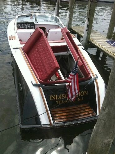 The interior of a white boat with red seats.