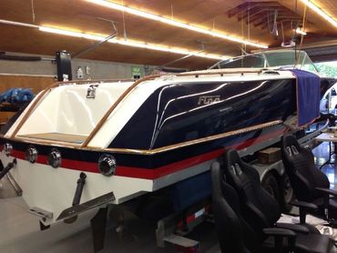The stern of a dark-colored boat with white stripes.