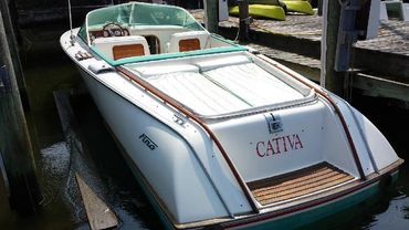 The stern of a white boat with a wooden deck and 'CATYA' on the back.