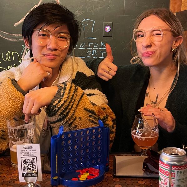 Two guests drinking sour beers and enjoying a game of connect four