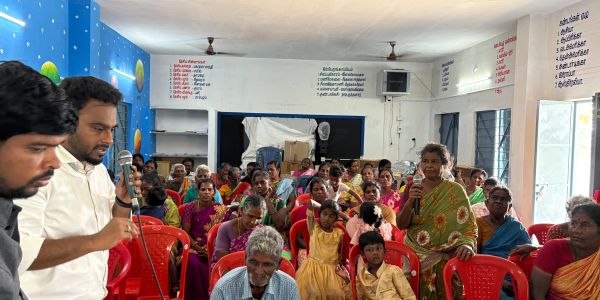 Community meeting with speakers and attentive audience.