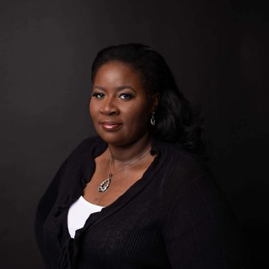 Confident woman in a black cardigan against a dark background.