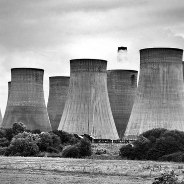 Large cooling towers at an industrial power plant emitting steam.