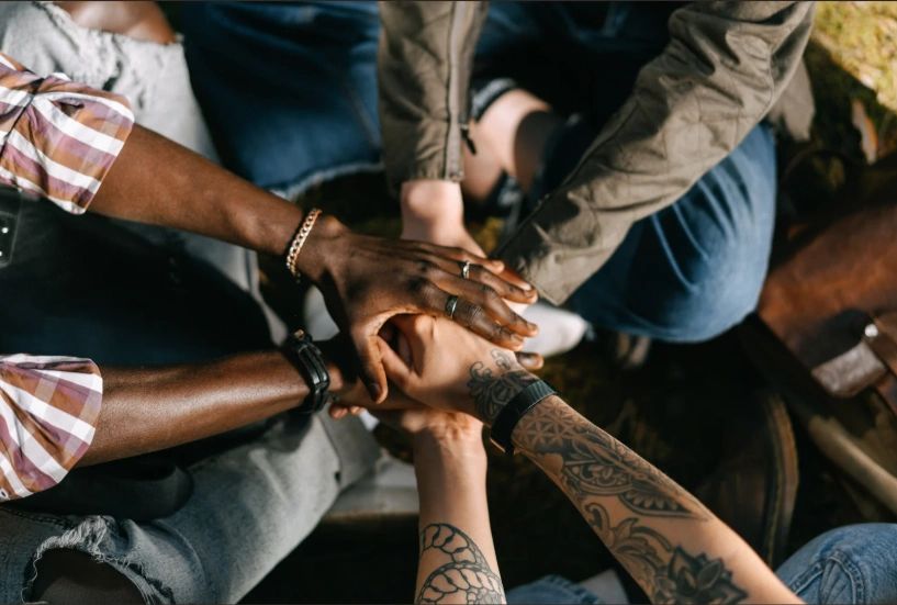 Diverse group showing unity with hands together.
