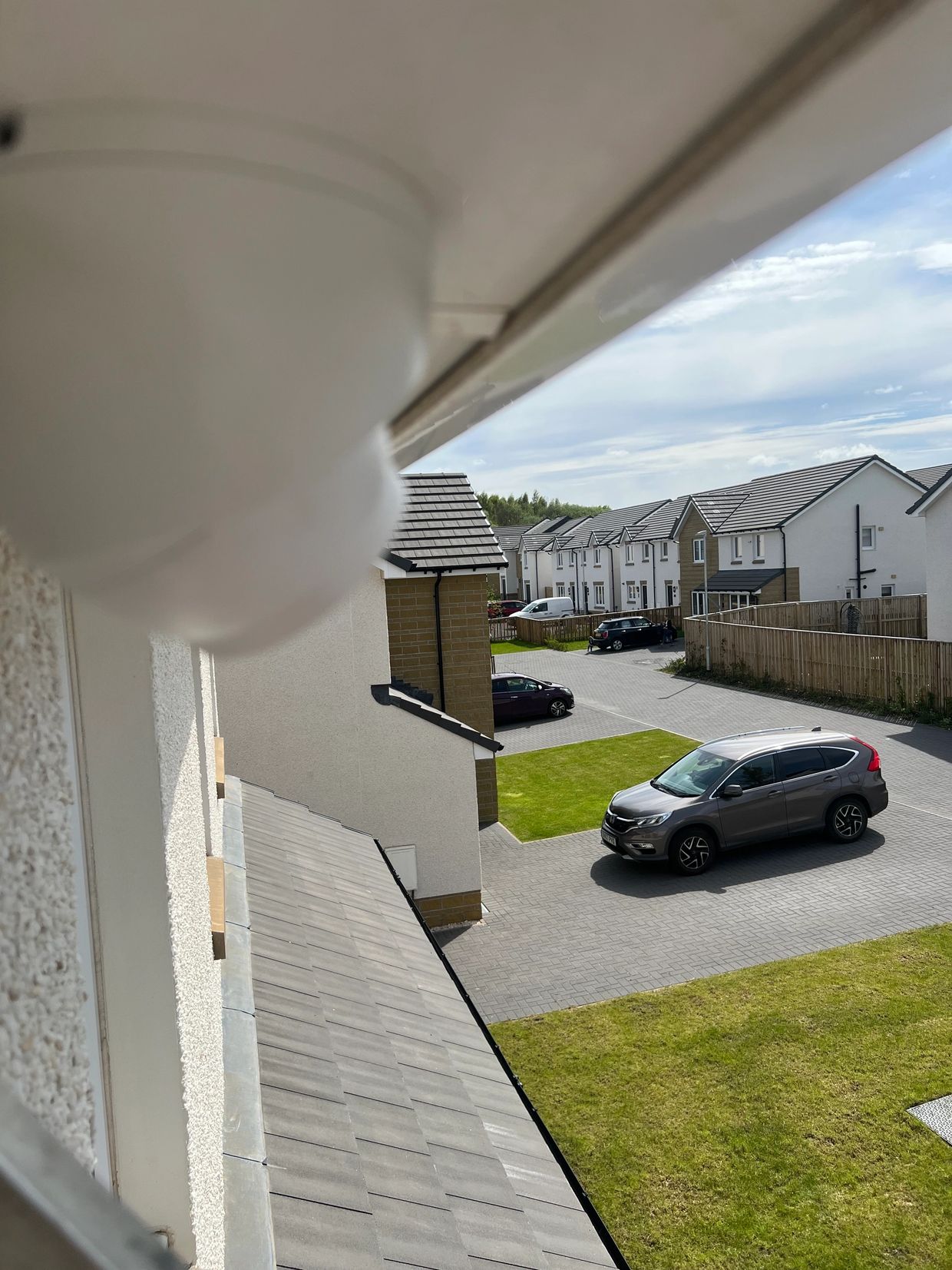 View of a suburban neighborhood with parked cars and houses.