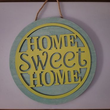 Decorative wooden sign saying "Home Sweet Home" in yellow and green.