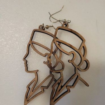 Close-up of wooden butterfly-shaped earrings on a white surface.