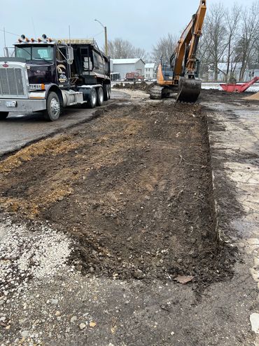 Construction site with dump truck and excavator moving dirt.