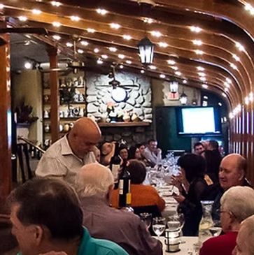 A cozy restaurant with diners and a live singer performing.