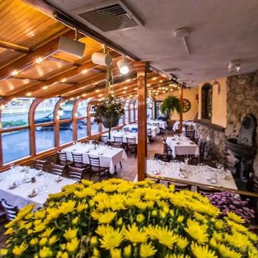 Elegant restaurant dining area with wooden accents and fresh yellow flowers.