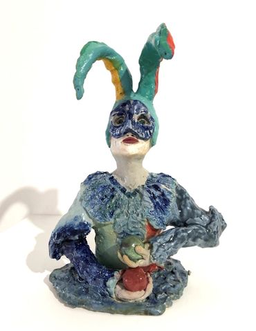 a small figurative ceramic sculpture waering a mask, with juggling balls in hand