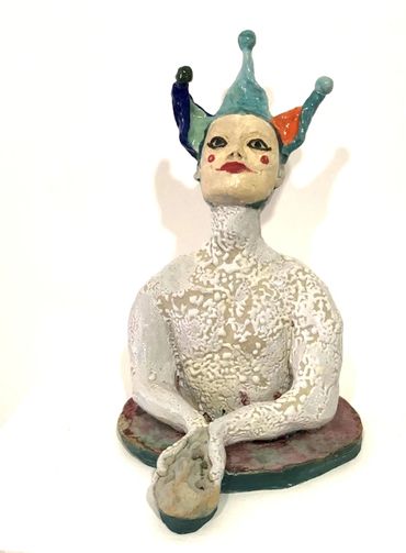 a small figurative ceramic sculpture of a jester like figure offering Munch's The Scream