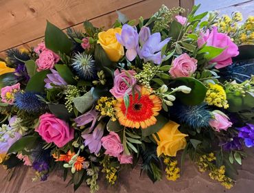 Colorful mixed flower bouquet with roses and greenery.