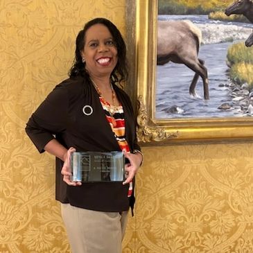 Dr. A Yvette Myrick accepting the mountain plains education association award of excellence in 2023