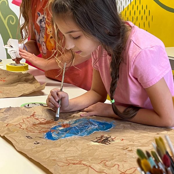 Child artist creating a painting; children's art classes in greenville, SC